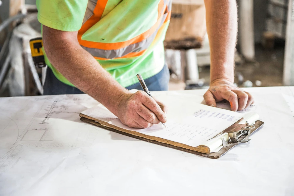 Site manager reviewing multiple building projects on a tablet dashboard